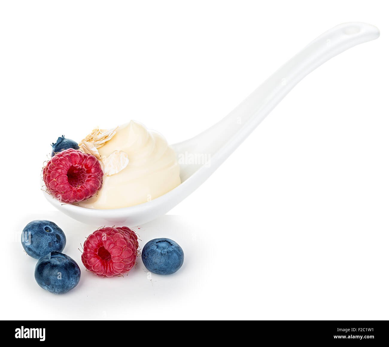 Spoon of raspberries and blueberries yogurt isolated on white Stock Photo