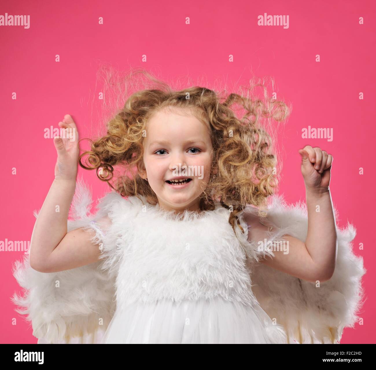 Beautiful little angel girl isolated on pink background Stock Photo - Alamy