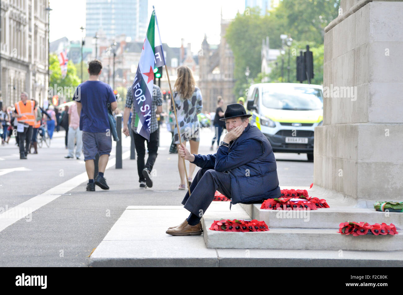 London 12th Sept 2015. Man sitting at the Cenotaph in Whitehall with a 'Freedom for Syria' flag. 'Refugees Welcome Here' rally, Stock Photo