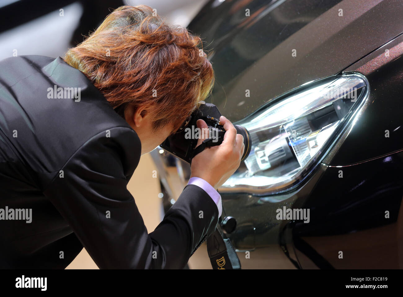 Frankfurt/M, 16.09.2015 - Japanese visitor takes very close photographs of details of a BMW car at the BMW stand at the 66th International Motor Show IAA 2015 (Internationale Automobil Ausstellung, IAA) in Frankfurt/Main, Germany Stock Photo