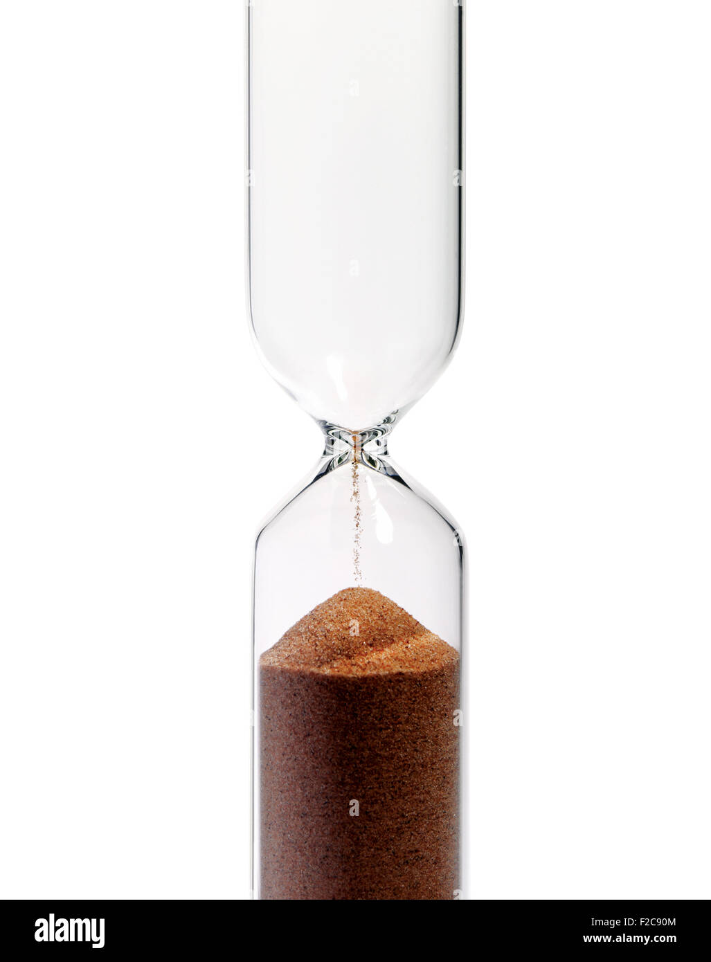 A vertical hourglass, isolated on white background, showing that the time has passed. Stock Photo