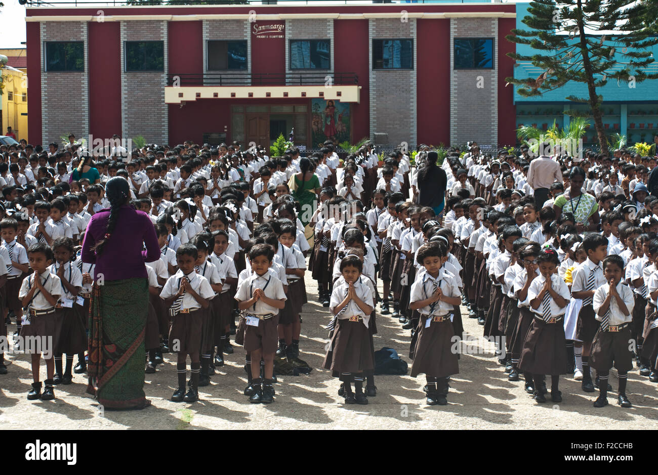 Schoolchildren are praying in the schoolyard before the course start ( India) Stock Photo