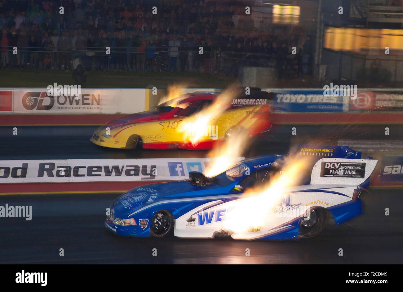 Top fuel funny car drag racing at Santa Pod. Gordon Smith driving a Dodge Stratus far side v Kevin Kent in a Ford Mustang. Stock Photo