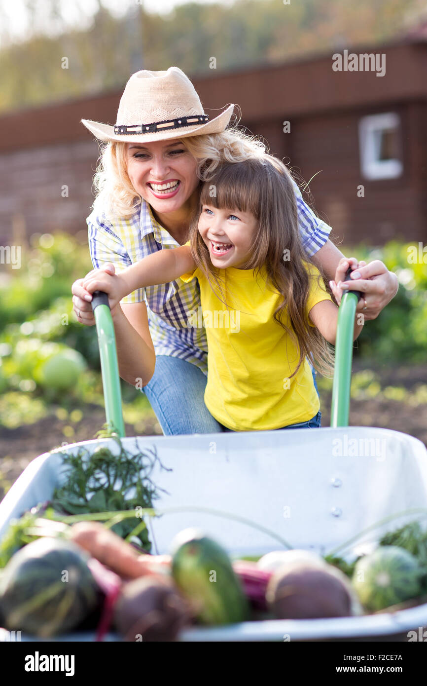 Mother and Daughter pushing Wheelbarrow with Harvest Stock Photo - Alamy