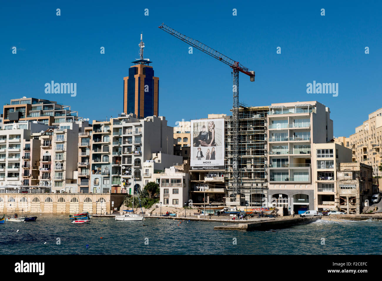 Malta, 2 january 2015 On the way to Spinola Bay in St Julian's. Lots of cafes and restaurants. And the highest building in malta Stock Photo
