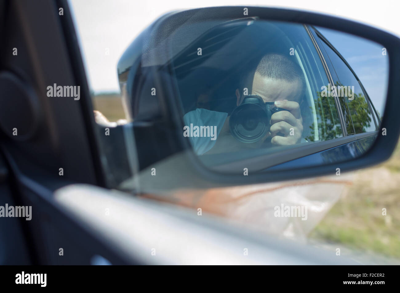 Reflection of Photographer Taking Picture in Car Side Mirror Stock Photo