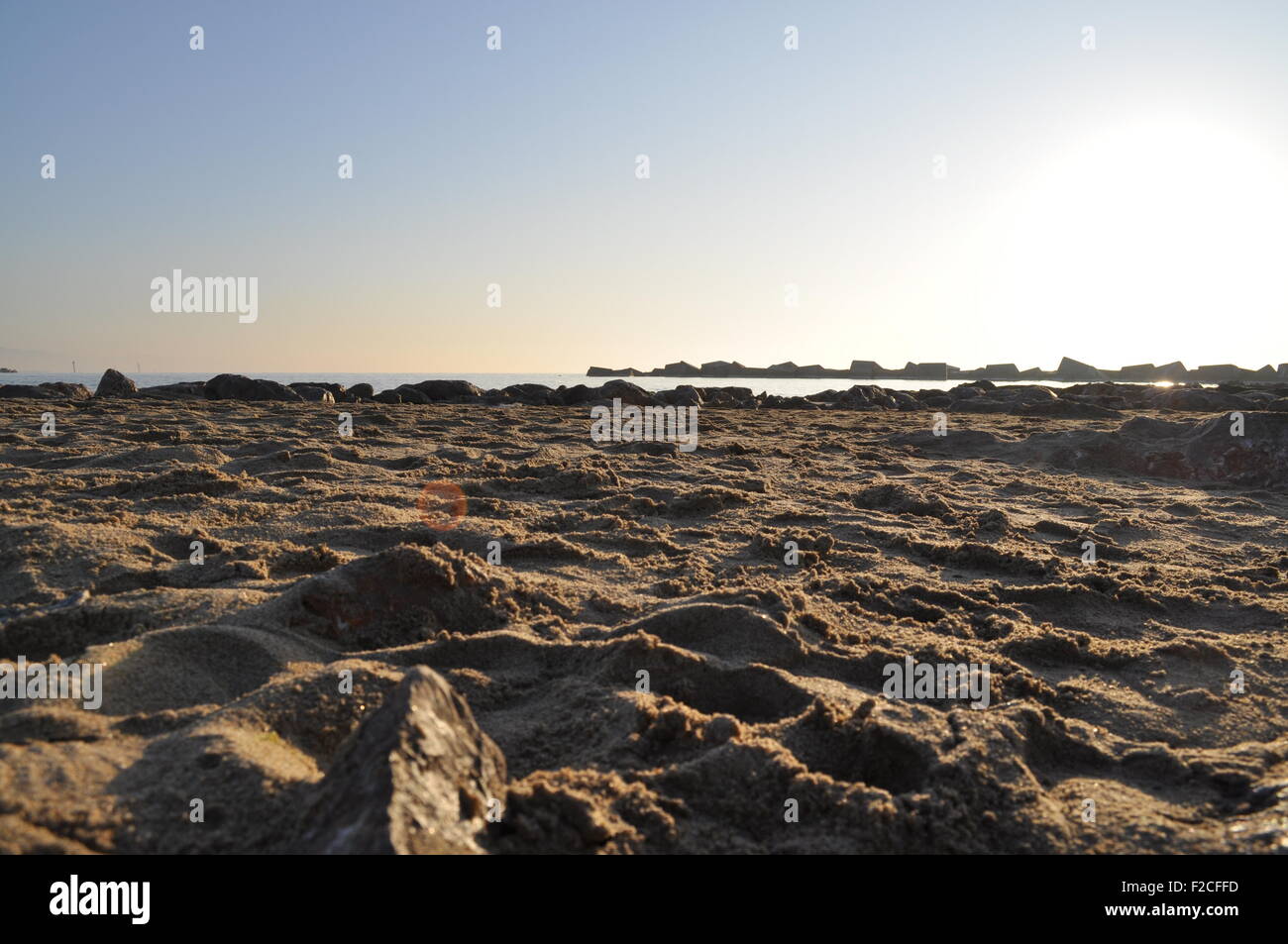 Rough sand on Barcelona beach during sunrise Stock Photo - Alamy