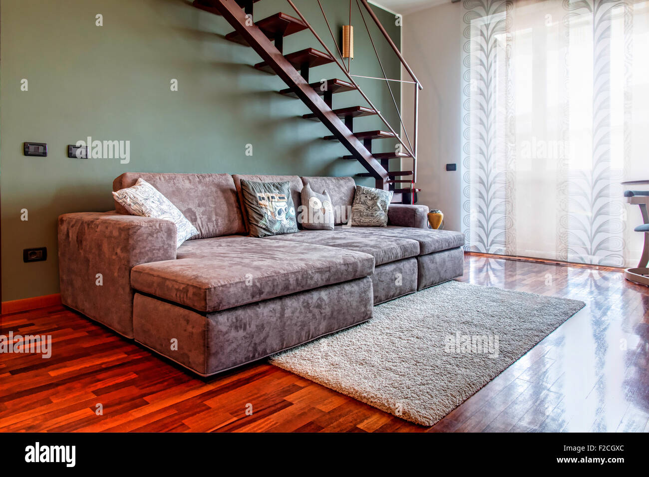 Simply living room with sofa, carpet and stairs Stock Photo