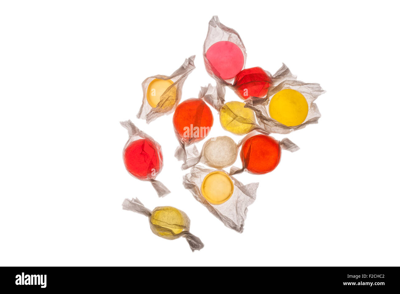 overhead view of orange, yellow, red, pink candy in wrappers on light table Stock Photo