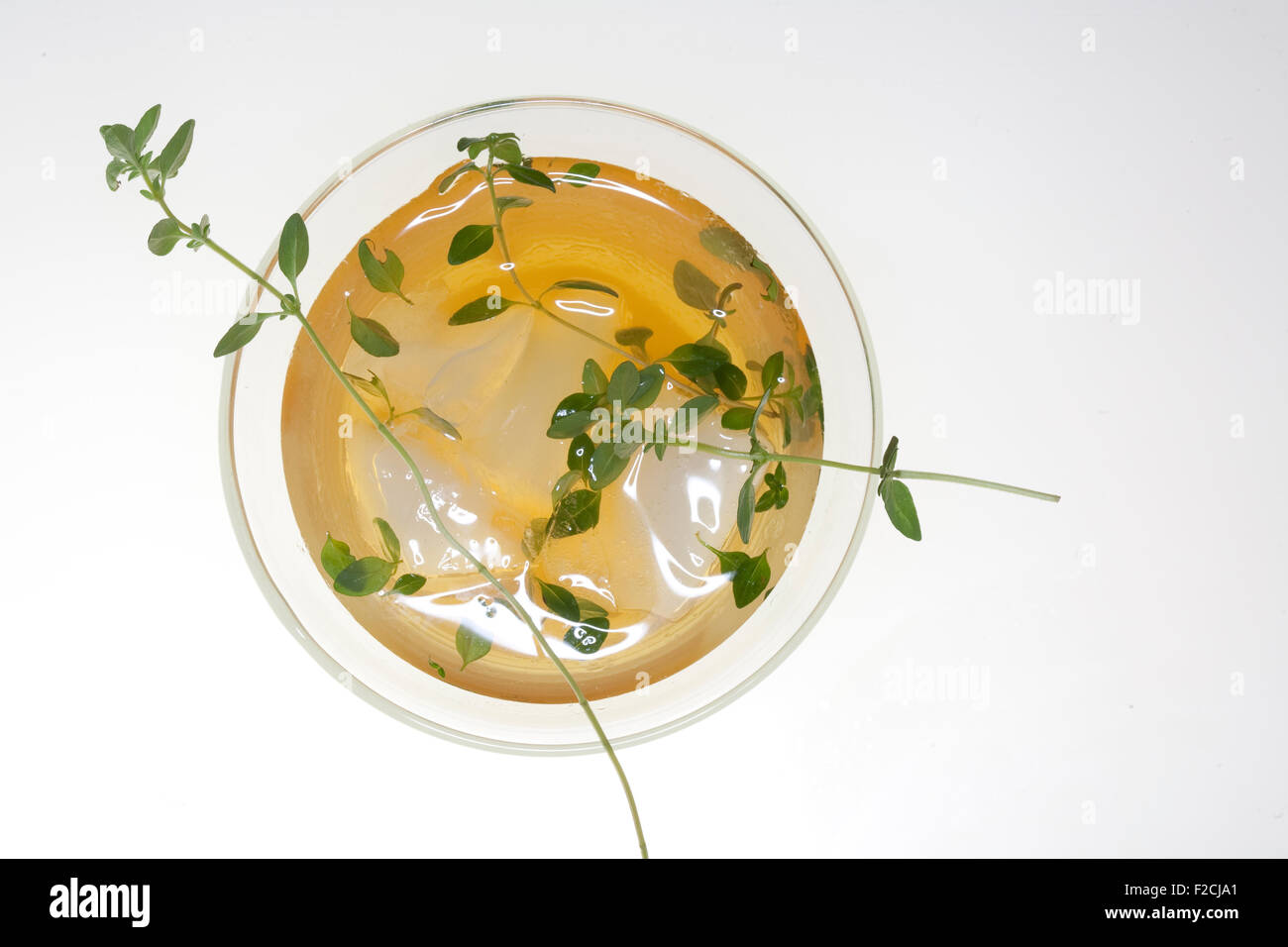 overhead view of cocktail in round glass with ice with thyme Stock Photo