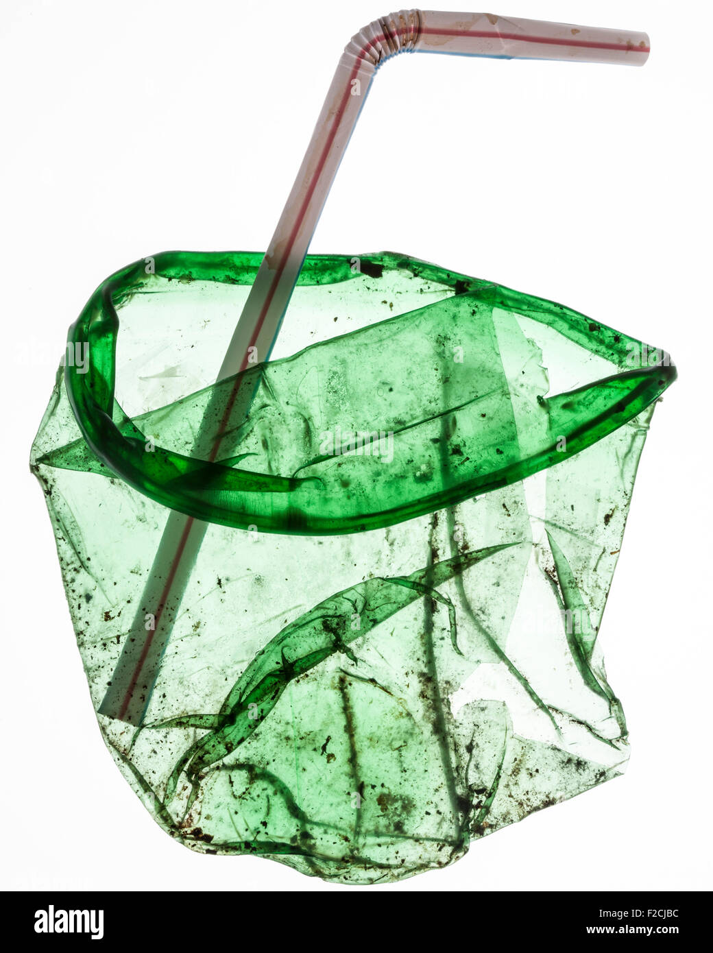 flattened, dirty green translucent plastic cup with bent straw Stock Photo