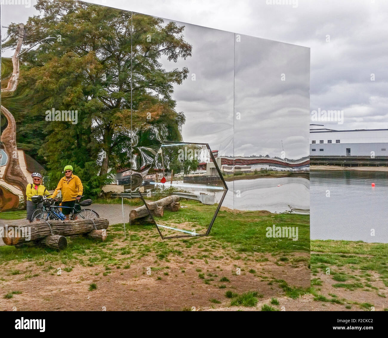 Bicyclists reflected in the mosaic of mirrors in mirror sculpture art along the Duwamish Waterway in Seattle, WA. Stock Photo