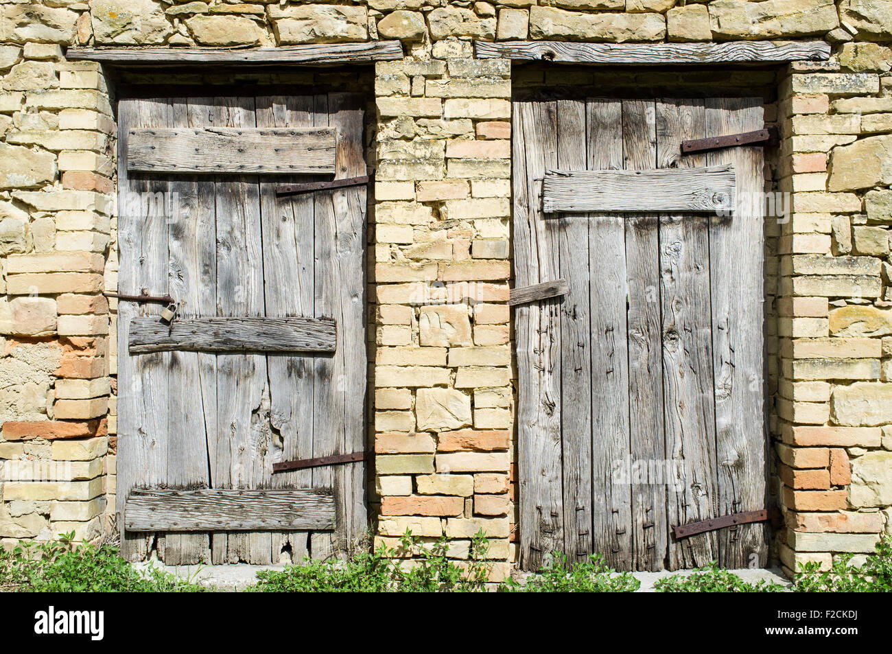 Old Stone Barn in Le Marche Italy with Two Weathered Wooden Doors Stock Photo