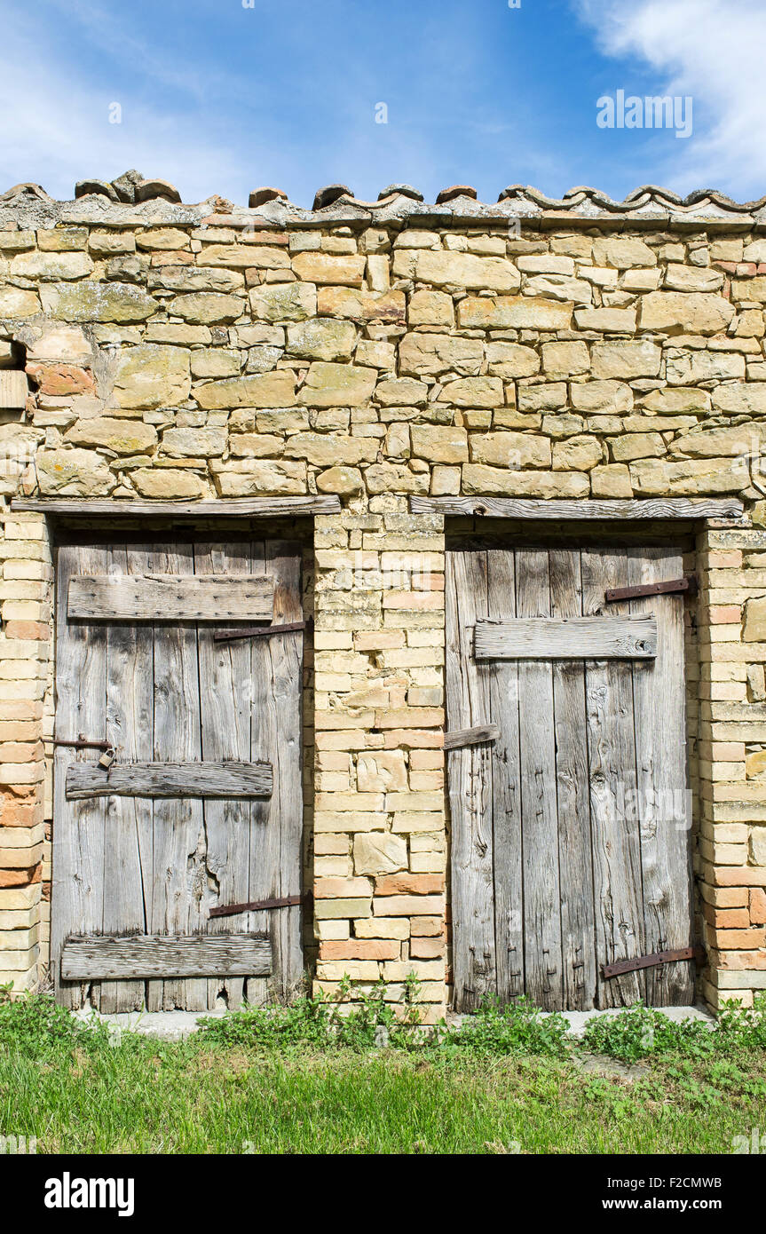 Old Stone Barn in Le Marche Italy with Two Weathered Wooden Doors Stock Photo