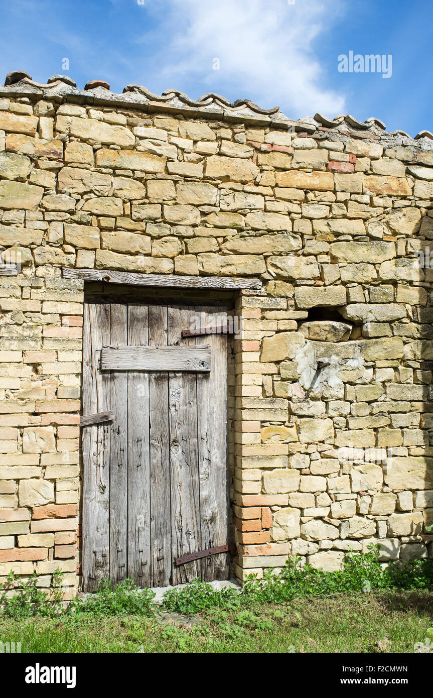 Old Stone Barn in Le Marche with Weathered Wooden Door Stock Photo