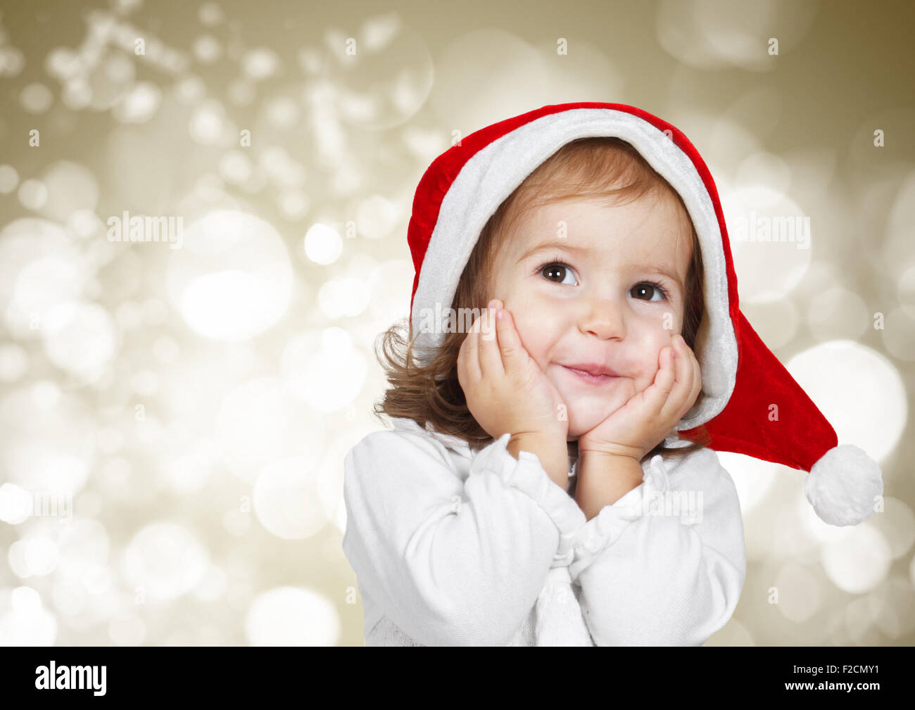 Funny child dressed santa hat, on bokeh background Stock Photo