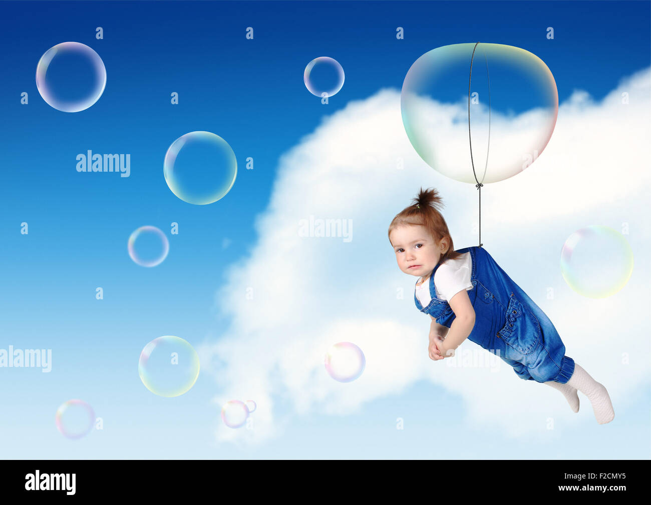 Funny child fly on soap bubble, flight creative concept Stock Photo