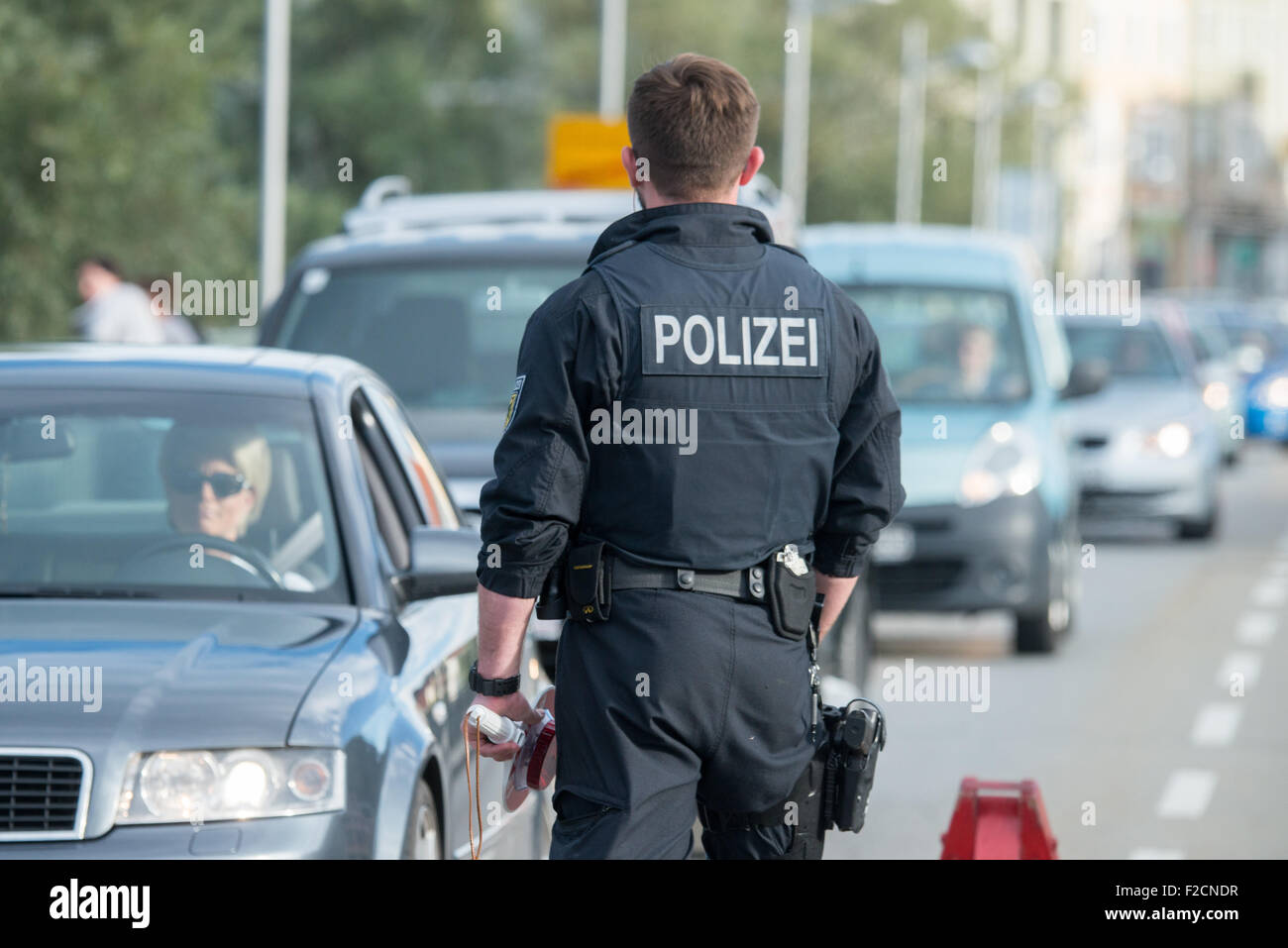 A police memeber controls a car on the border beteween Austria and Germany near Laufen, Germany, 16 Septemeber 2015. Photo: ARMIN WEIGEL/DPA Stock Photo