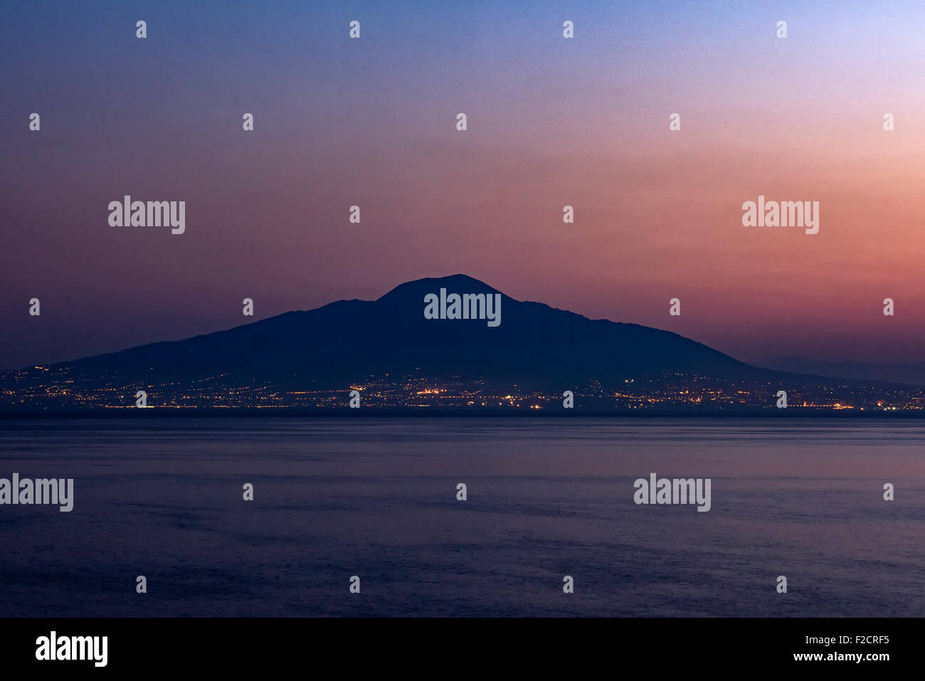 Torre del Greco at dusk with Mount Vesuvius volcano in the background, Naples, Italy Stock Photo