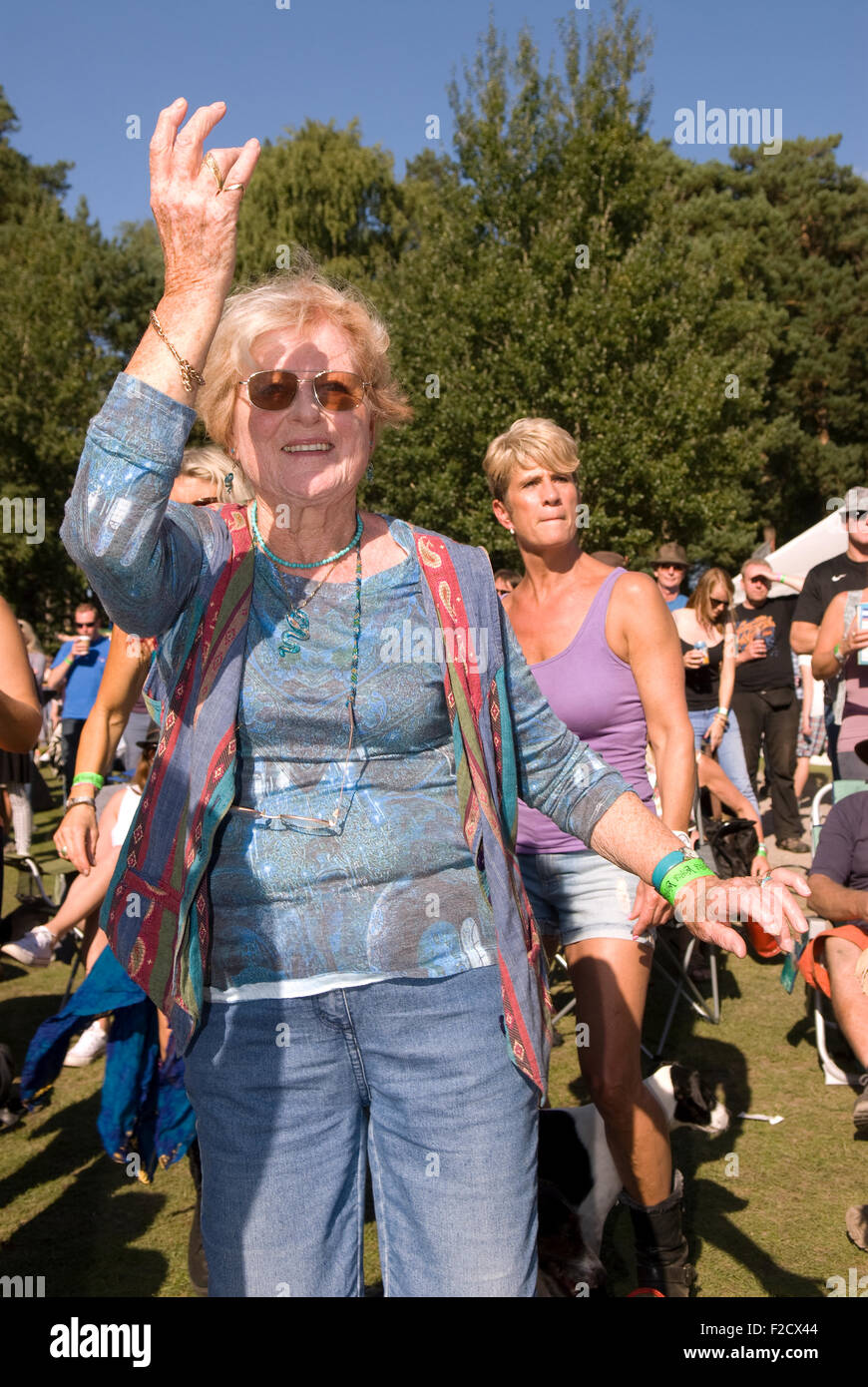 Elderly woman having a boogie amongst the crowds at Weyfest Music Festival 2015, Rural Life Centre, Tilford, Farnham, Surrey, UK Stock Photo