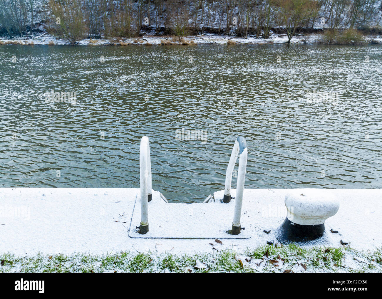 Mooring bollard and the top of a ladder or steps on the side of the River Trent during Winter. Nottinghamshire, England, UK Stock Photo