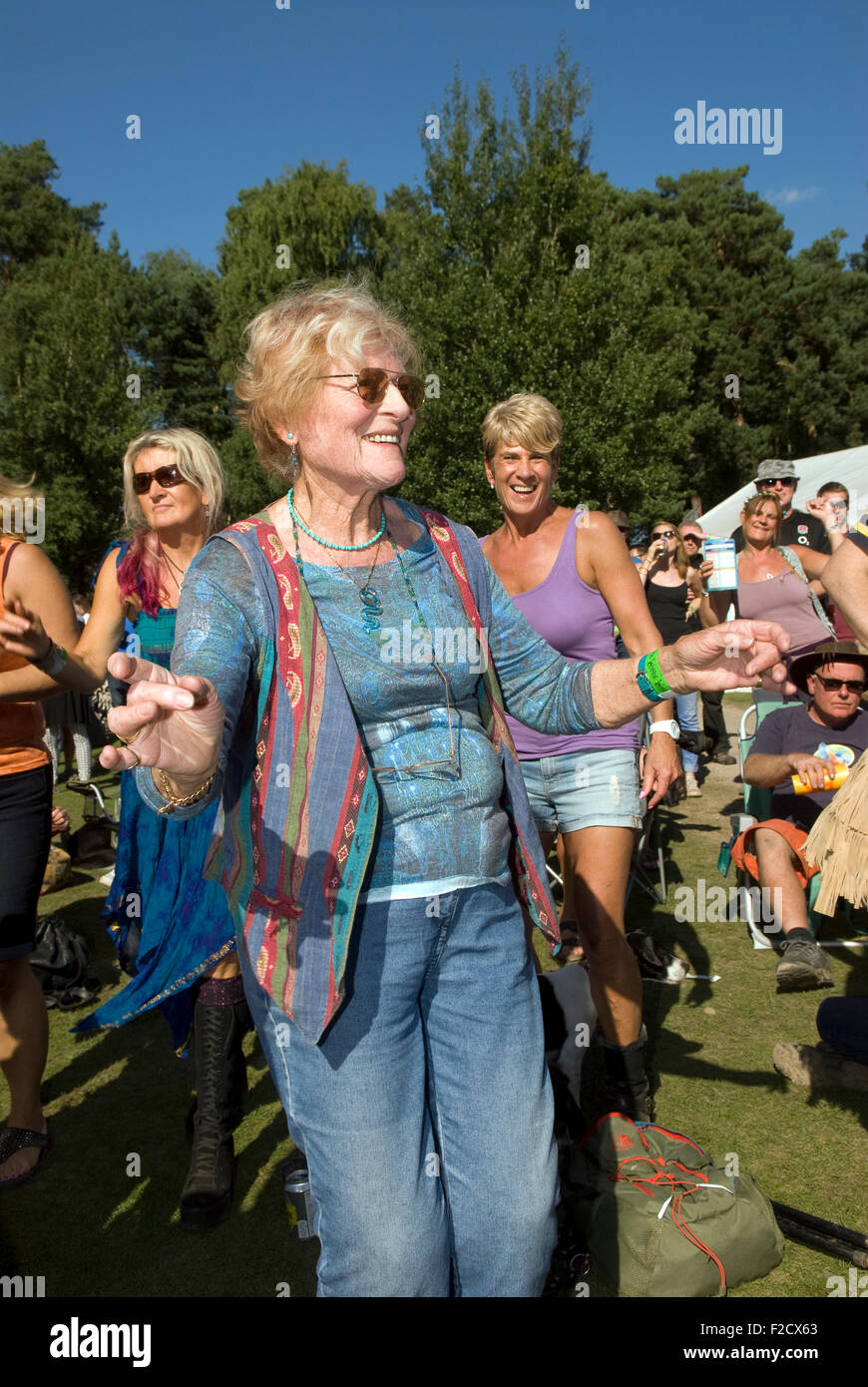 Elderly woman having a boogie amongst the crowds at the 3-day Weyfest Music Festival 2015, Rural Life Centre, Tilford, Farnham, Stock Photo