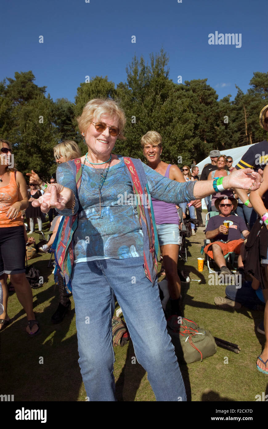 Elderly woman having a boogie amongst the crowds at the 3-day Weyfest Music Festival 2015, Rural Life Centre, Tilford, Farnham, Stock Photo