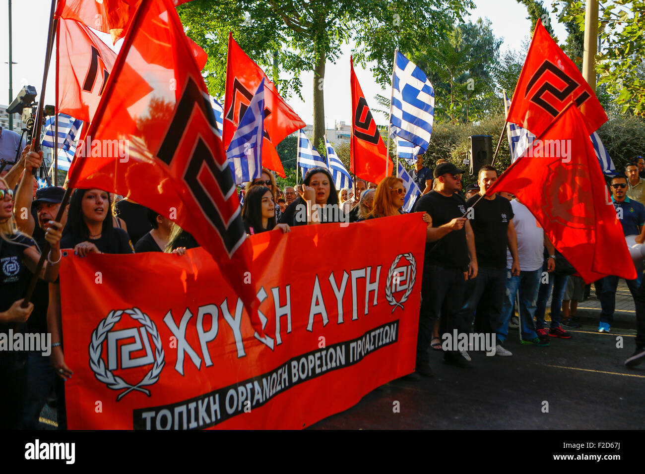 Athens, Greece. 16th Sep, 2015. Golden Dawn supporters carries a banner and Golden Dawn and Greek flags at the election rally in Athens. Greek right wing party Golden Dawn held an election rally in Athens, four days ahead of election day. The party hopes to gain enough seats in the election to become the third latest party in the Greek Parliament. Credit:  Michael Debets/Pacific Press/Alamy Live News Stock Photo
