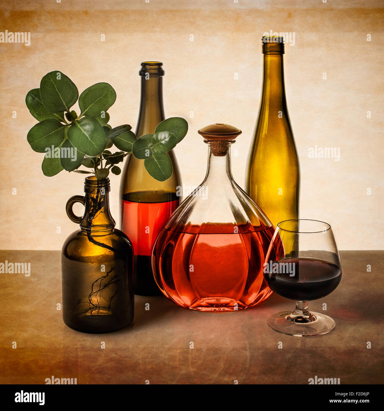 Still life with wine bottles and greenery Stock Photo