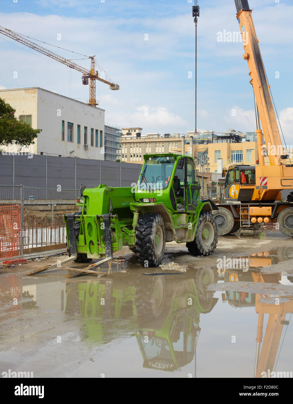 Green excavator in a construction site Stock Photo