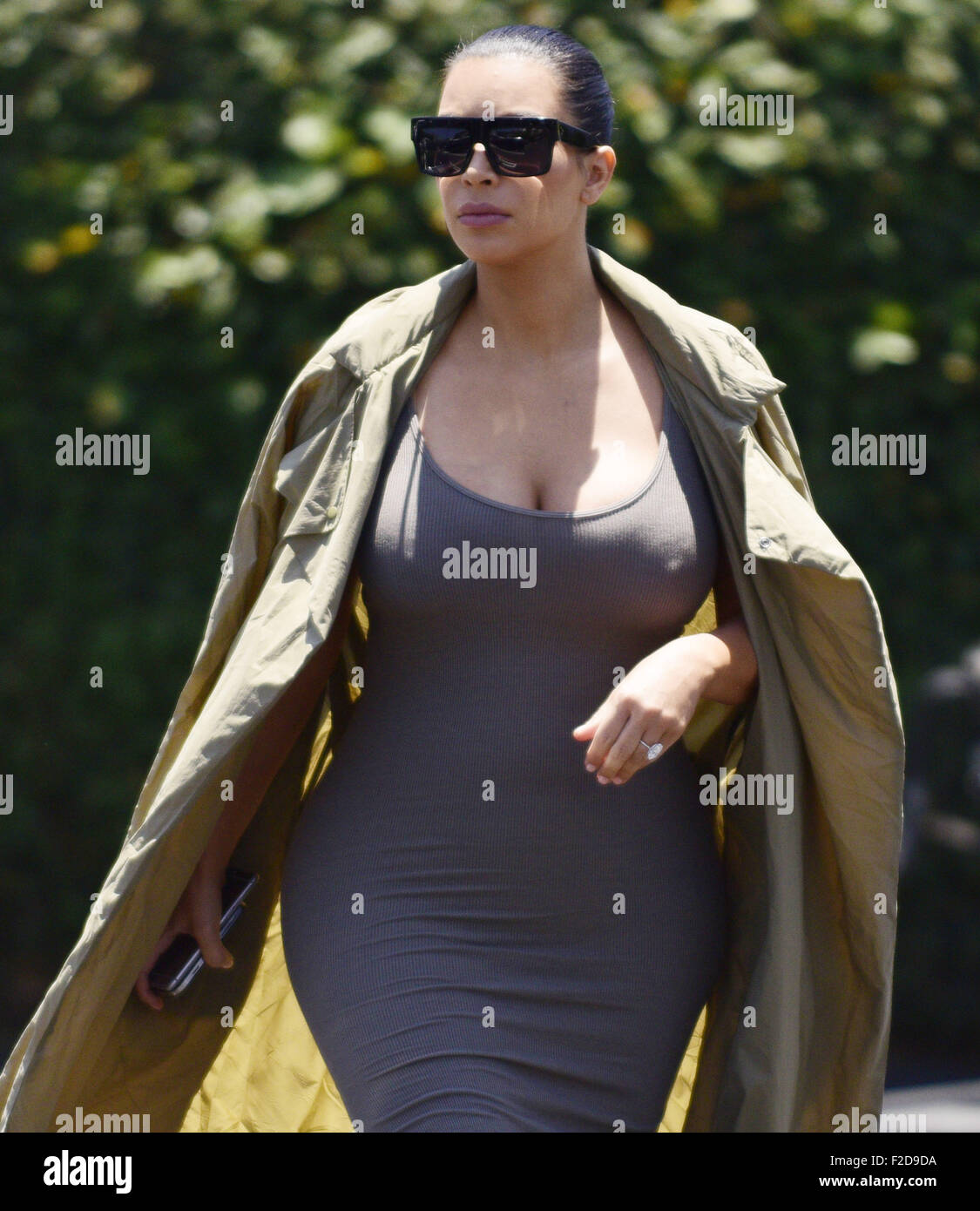 Pregnant KIM KARDASHIAN sports a skin tight dress and a trench whilst out with friends in West Hollywood.  Featuring: Kim Kardashian Where: Los Angeles, California, United States When: 17 Jul 2015 Stock Photo