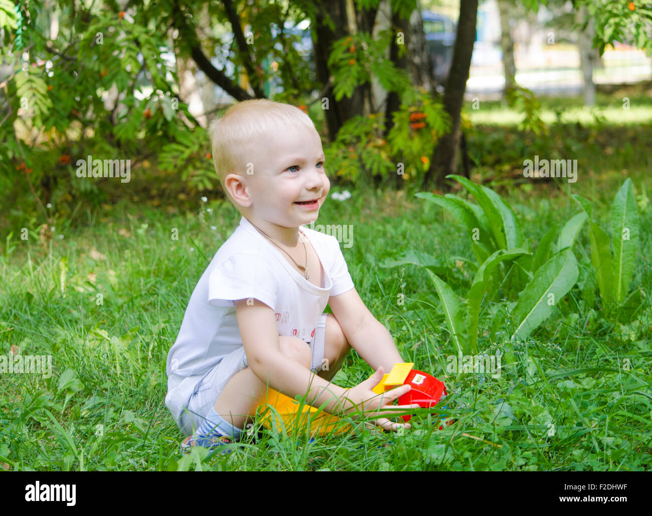 the child smiles,the child,2 years,walk,pleasure,game,a smile,summer,park,the nature Stock Photo