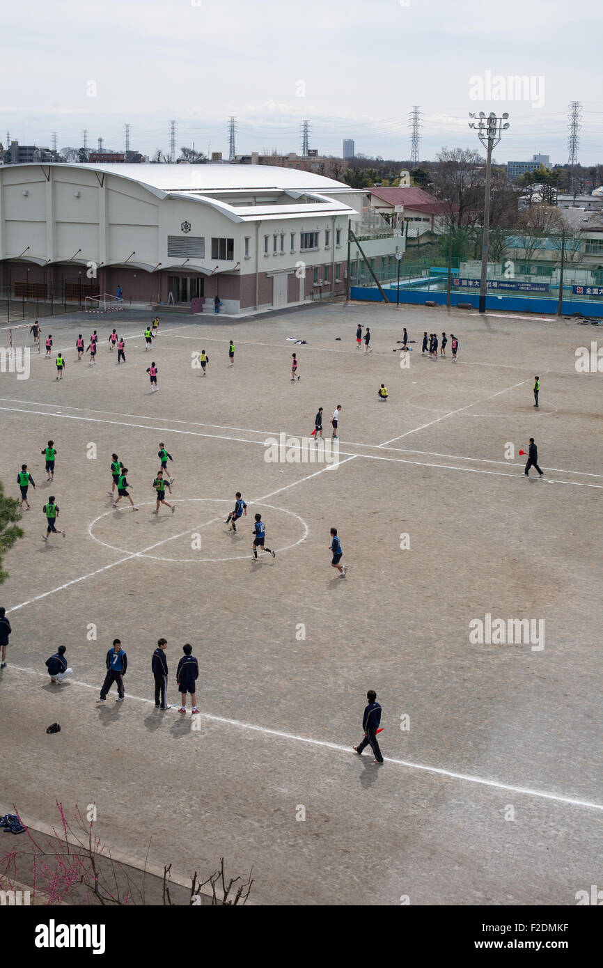 Dirt schoolyard with kids playing soccer football pov from above right open space Stock Photo