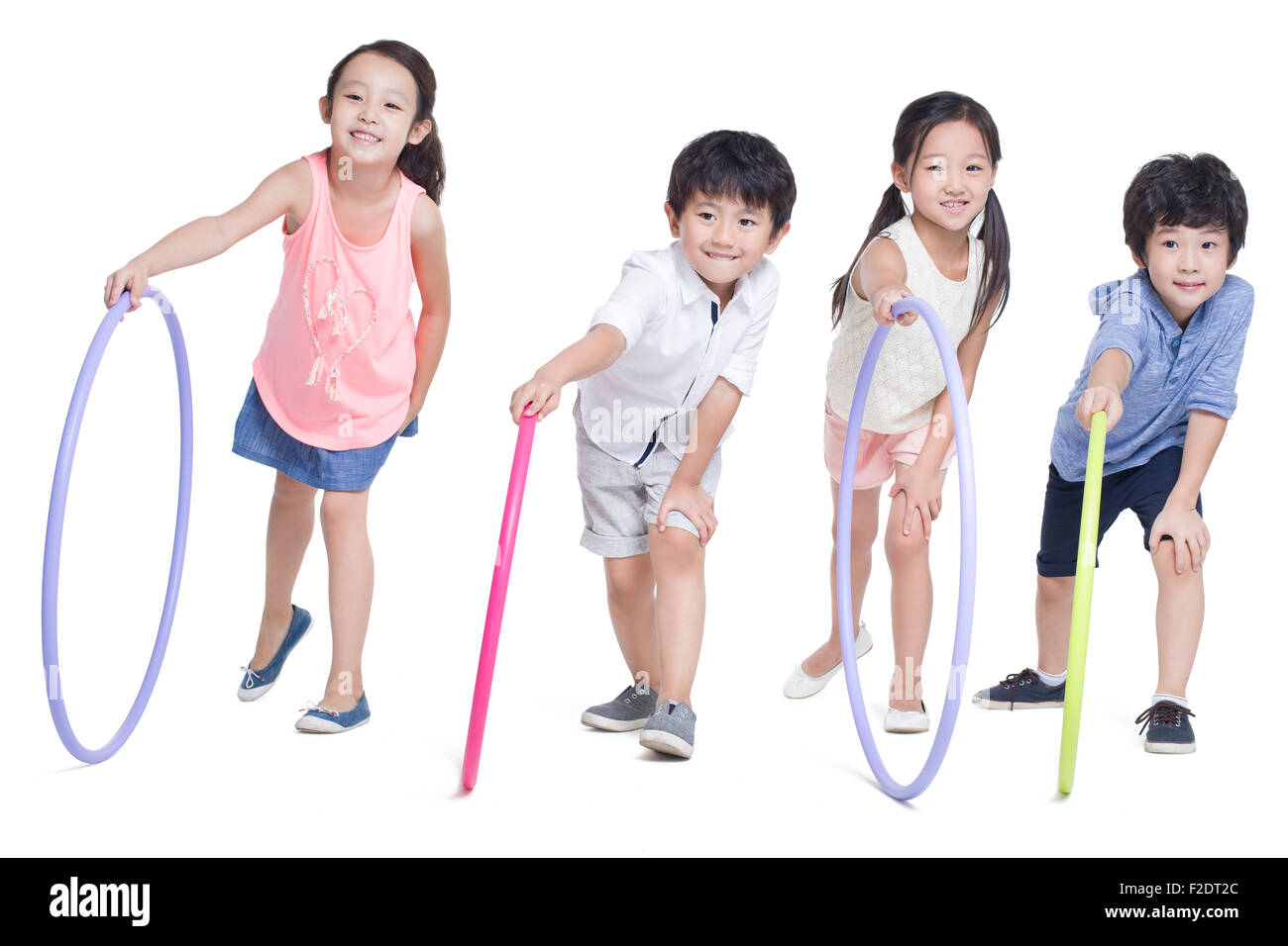Happy children rolling plastic hoops Stock Photo Alamy