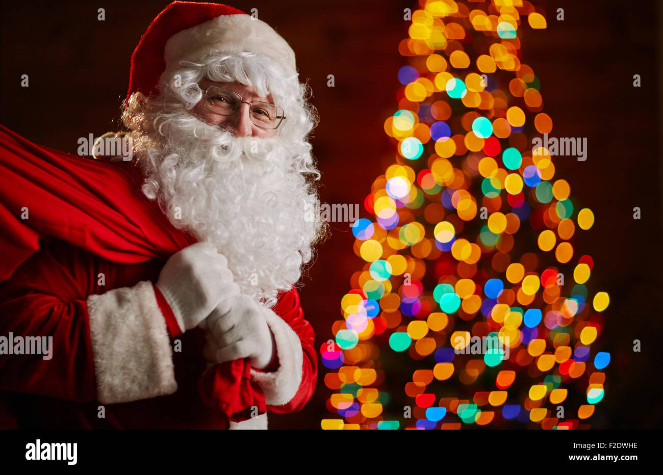 Santa Claus holding carrying sack with gifts for kids Stock Photo - Alamy