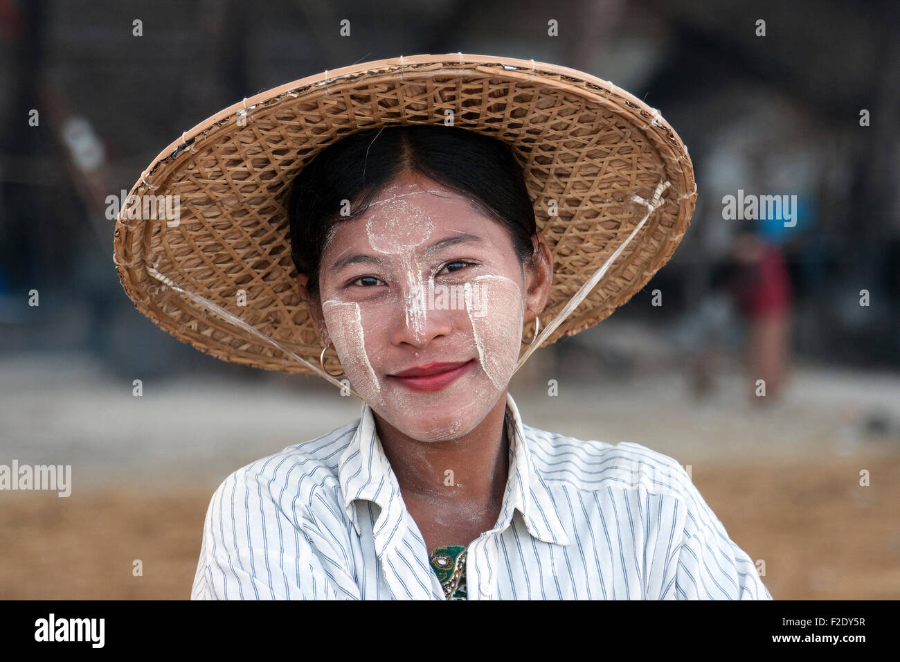 Local woman wearing a straw hat and Thanaka paste on her face, smiling, portrait, Ngapali, Thandwe, Rakhine State, Myanmar Stock Photo