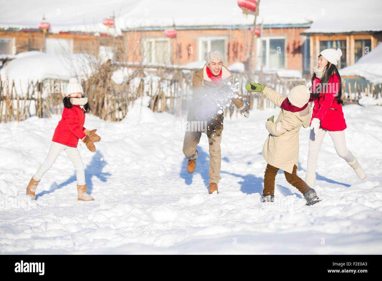 Young family having a snowball fight in the snow Stock Photo