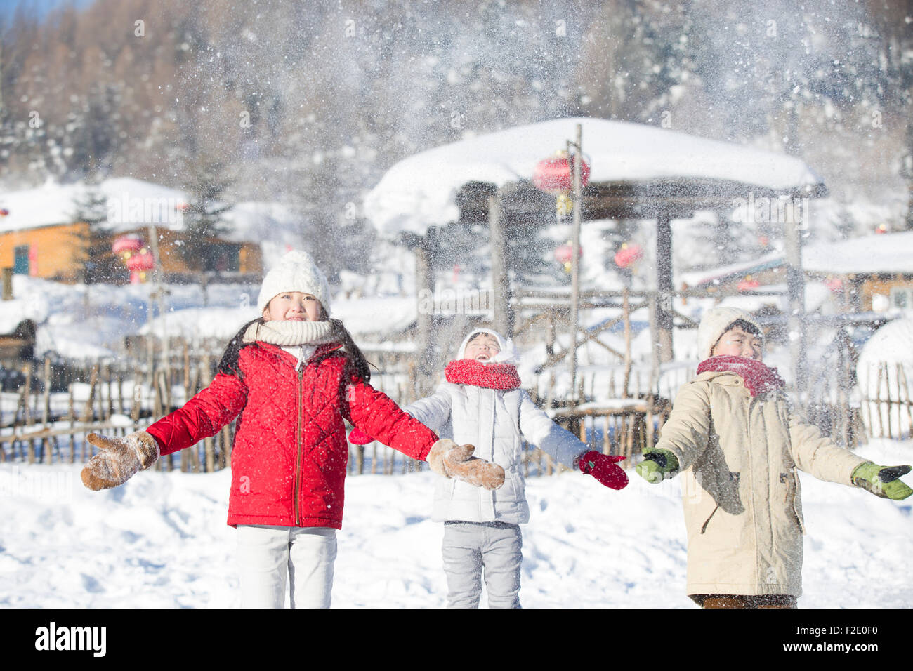 Three children catching the falling snow together Stock Photo - Alamy