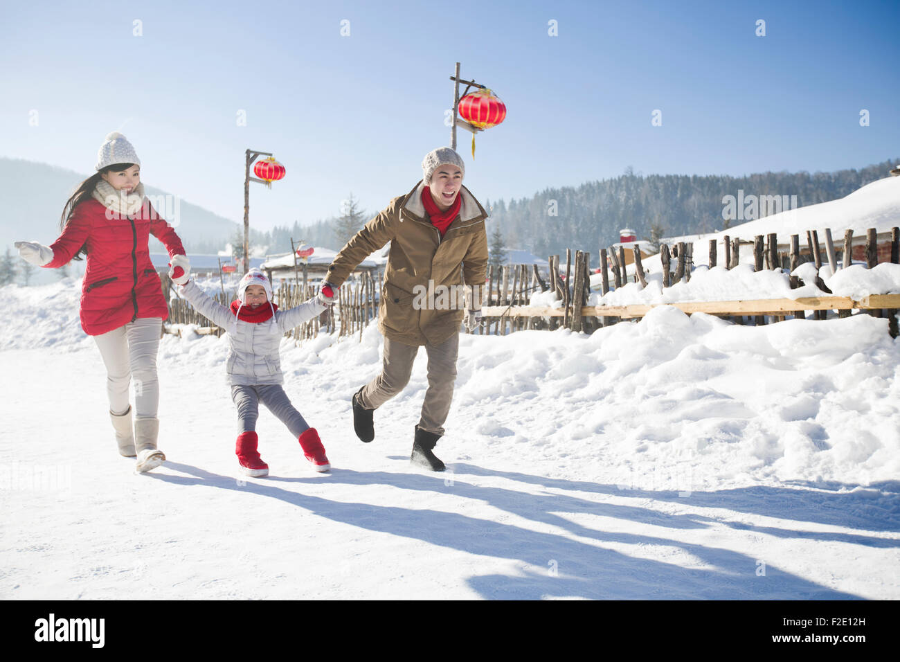 Happy family playing in the snow Stock Photo - Alamy
