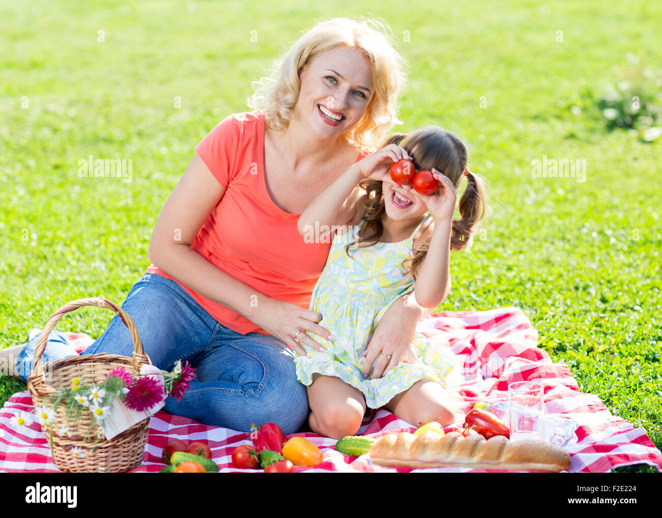Family mother and little daughter play having picnic in summer park Stock Photo