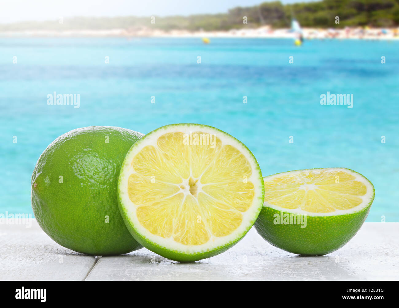 Lime on white wood table photographed at eye level on the beach Stock Photo