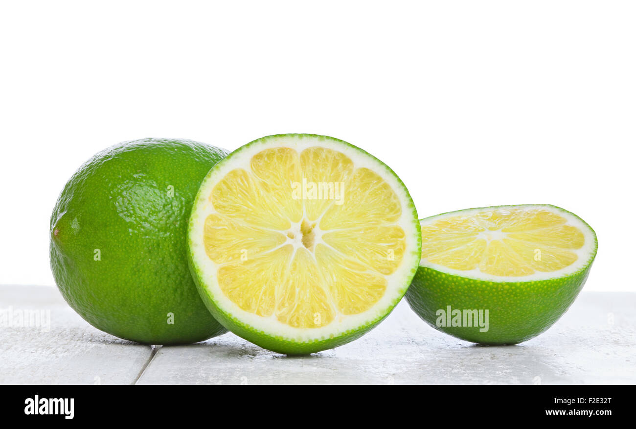 Lime on white wood table photographed at eye level Stock Photo
