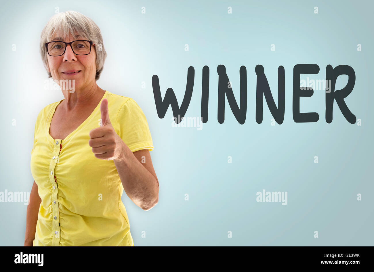 Senior woman showing thumbs up winner concept. Stock Photo