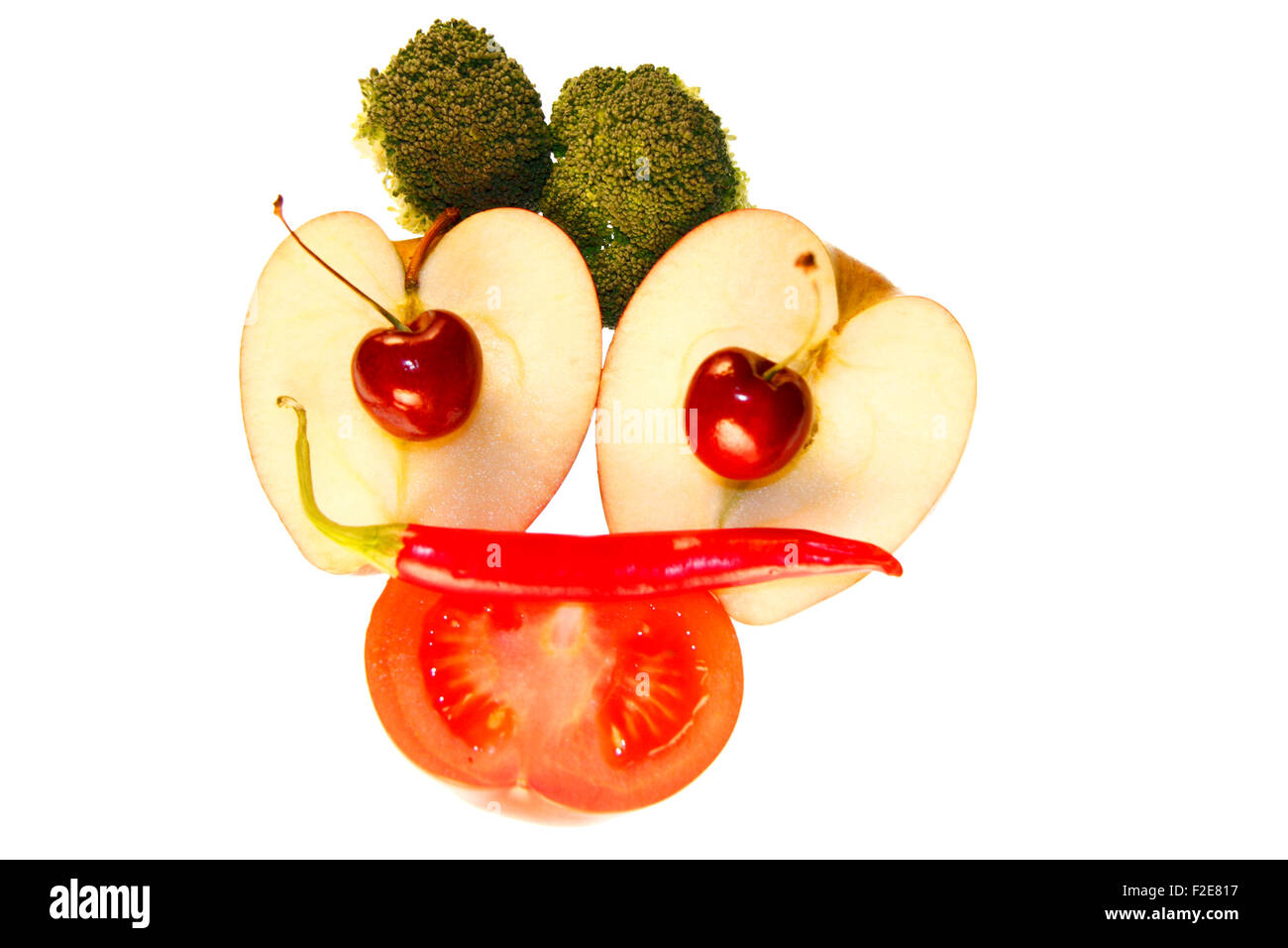 Gesicht/ face: Brokkoli, Kirschen, Apfel, Tomate, Chilly - Symbolbild Nahrungsmittel . Stock Photo