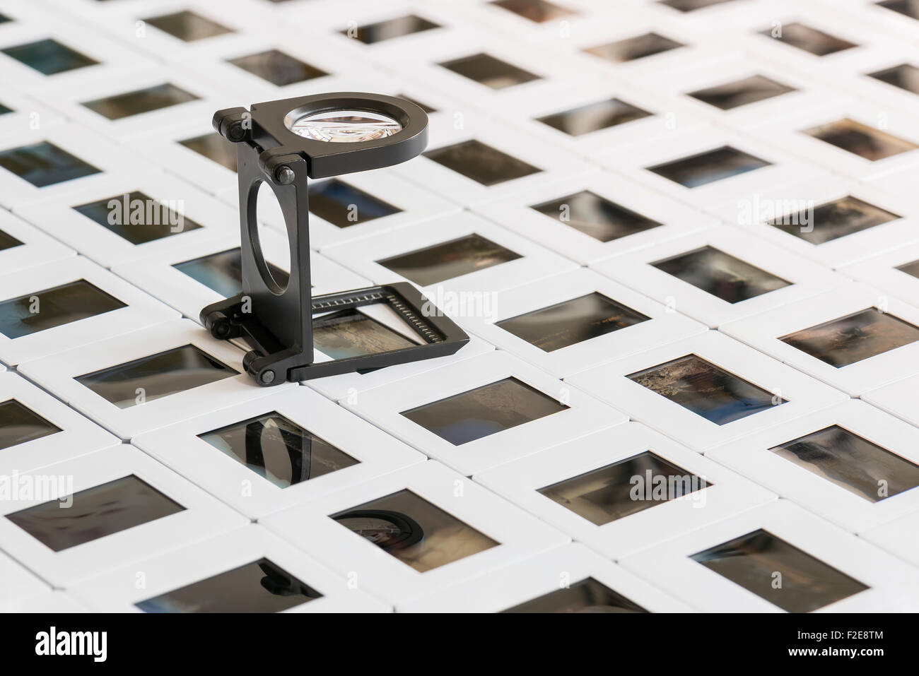 series of photo slides on a table with loupe Stock Photo