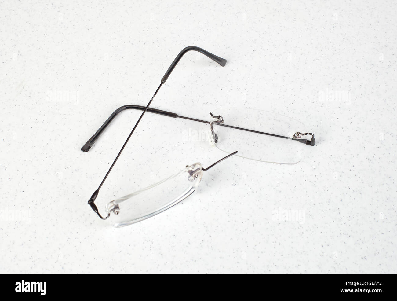 Eyeglasses with lightweight frame broken on white table. Stock Photo