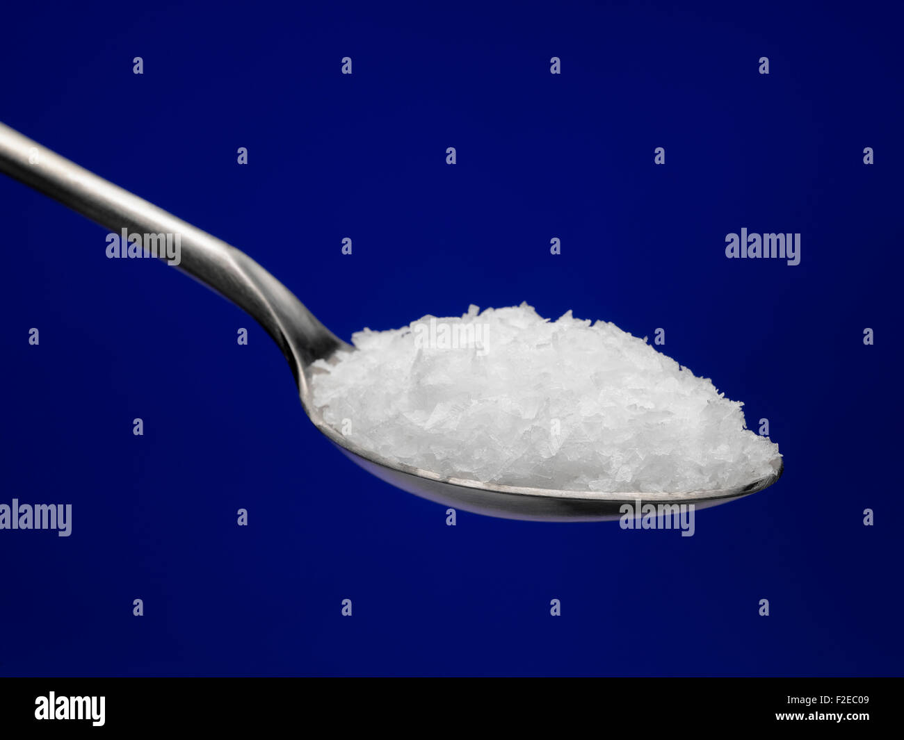 Sea Salt on spoon with a blue background Stock Photo