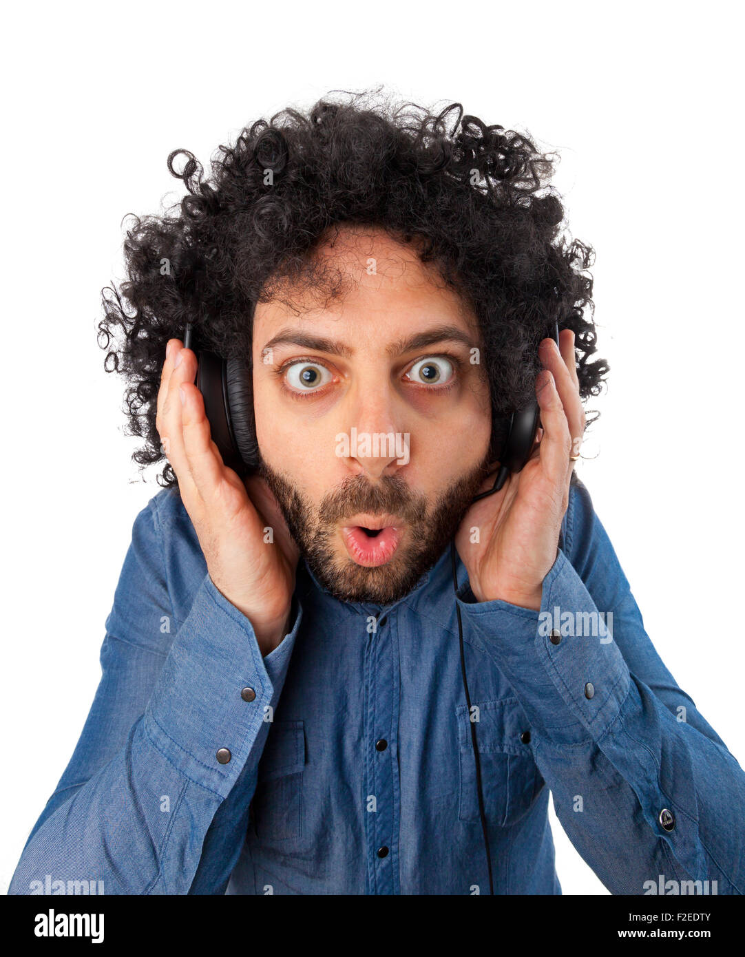 Young surprised man with headphones on white background. Stock Photo