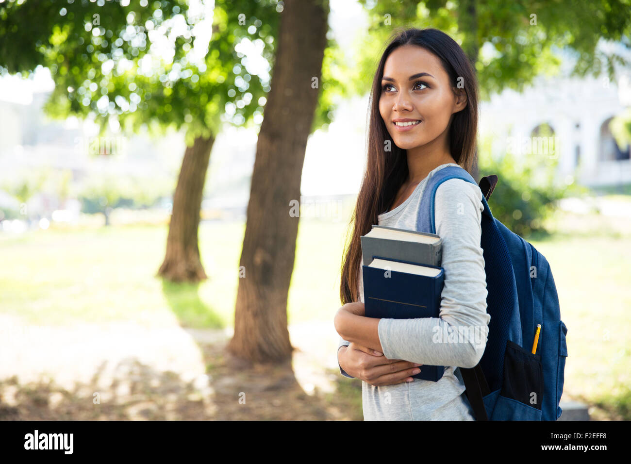 Portrait of a smiling female student walking outdoors Stock Photo