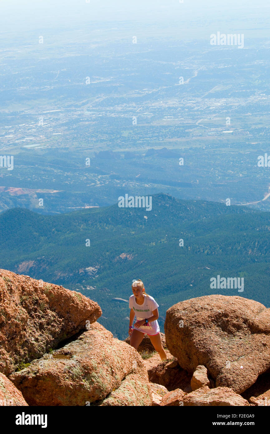 Woman runs in a rugged race up 14,115 foot Pikes Peak on the Barr Trail near Manitou Avenue in Manitou Springs Colorado Stock Photo